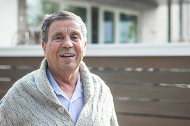 Evin önünde gülümseyen son sınıf öğrencisi. Kameraya bakan mutlu son sınıf öğrencisinin portresi