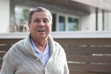 Evin önünde gülümseyen son sınıf öğrencisi. Kameraya bakan mutlu son sınıf öğrencisinin portresi