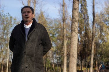 Parkta yürüyen dalgın kıdemli adam.