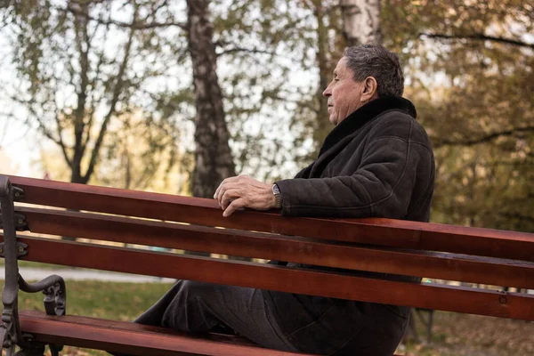 Lonely senior man sitting on bench