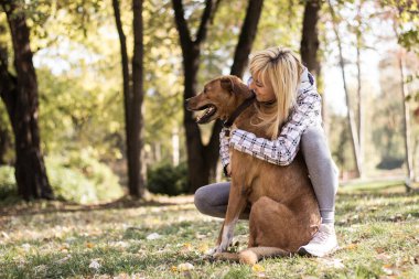 genç kadın köpeğini kucaklayan