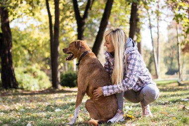 genç kadın köpeğini kucaklayan