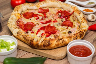 Sucuklu, jambonlu, biberli ve pizza malzemeli lezzetli pizza.