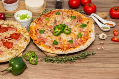 Biberli pizza ve pizza mozzarella peyniri, jambon, domates sosu, salam, mantar, biber, baharat ve taze fesleğen.