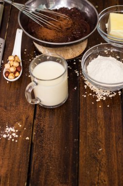 Pasta pişirme malzemeleri. Tahta arka planda çikolatalı pasta pişirmek için gerekli malzemeler.