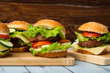 Ahşap masada servis edilen taze ızgara burgerler.