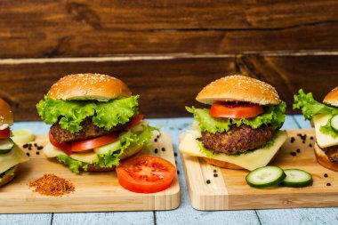 Ahşap masada servis edilen taze ızgara burgerler.