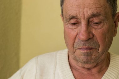 Yüzünde ciddi bir ifade olan kıdemli bir adam.