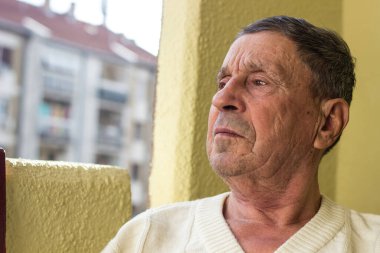 Yüzünde ciddi bir ifade olan kıdemli bir adam.