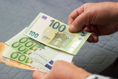 Kıdemli kadın evde para sayıyor.