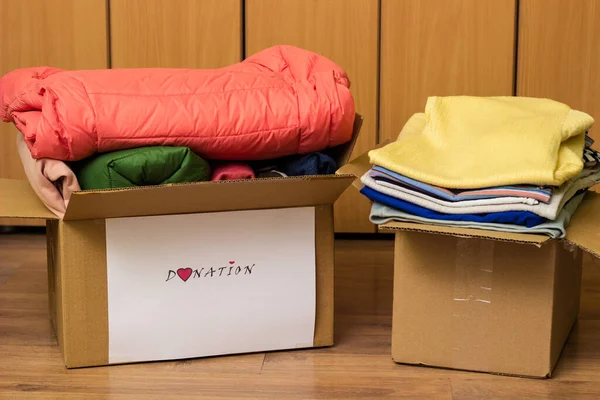 Clothes Donation. Box of warm cloth with donate label. Gathering items to be donated to charity