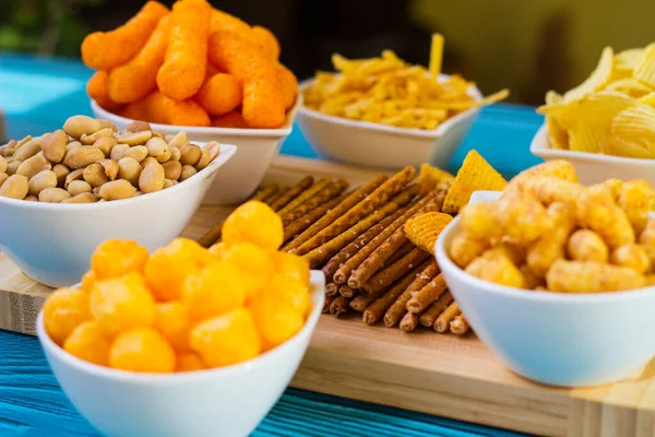 Salty snacks served as party food in bowls. Party food