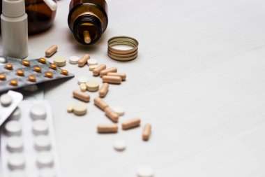 Variation of vitamins and pills on a green leaf on a white background