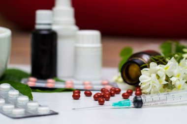 Variation of vitamins and pills on a green leaf on a white background