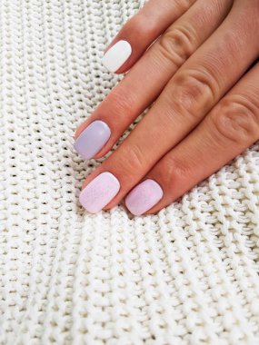 Beautiful pink, white and purple manicure with crystals on female hand