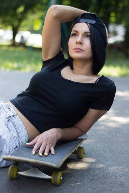 Teen girl with her skateboard , the basketball court