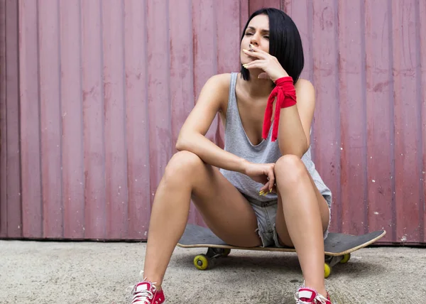 Young Woman Sitting Her Skateboard Smoking Cigarette — Foto de Stock