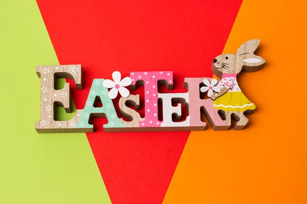 Easter bunny with eggs on colorful wall with copy space