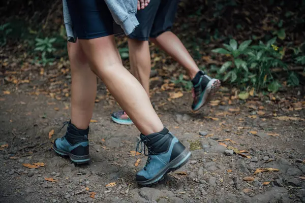 Close-up shot of the legs of a sporty couple walking along a path