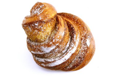 Yeni pişmiş tarçınlı çörek. Pudra şekeri serpilmiş. Yakın plan fotoğraf. Beyaz bir arkaplanda.