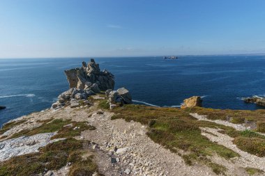 Güneşli bir günde Pointe de Pen-Hir yakınlarında kaya oluşumuna doğru yürüyüş yolu, Camaret-sur-Mer, Parc naturel bölgesel Armorique, Brittany, Fransa