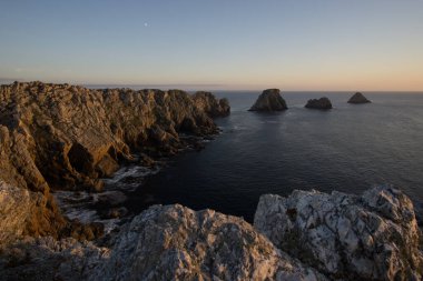 Gün batımında Pointe de Pen-Hir sahilinde gökyüzünde ay ışığı, Camaret-sur-Mer, Parc naturel bölgesel Armorique, Brittany, Fransa