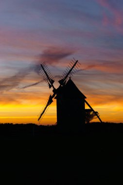 Günbatımından sonra canlı ve dramatik bir gökyüzü geleneksel yel değirmeni silueti Moulins de Trouguer, Cleden-Cap-Sizun, Brittany, Fransa