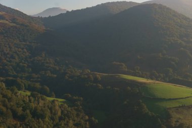 Beartzun, Navarre, İspanya yakınlarındaki İspanyol Fransız sınırında altın güneş ışığında yeşil tepeleri olan güzel bir Bask kırsalı.