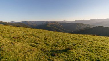 Basque landscape at golden hour during sunset with beautiful hills and meadow in foreground, Aiako Harria, Gipuzkoa, Basque Country, Spain clipart