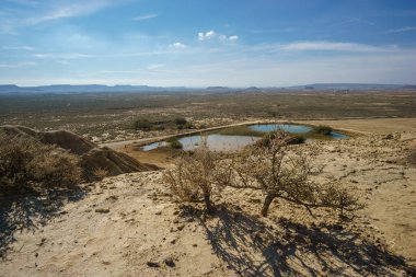 Bardenas Reales 'in kurak platosunun Mirador de Juan Obispo, Arguedas, Navarra, İspanya' daki küçük gölü ile çöl manzarası.