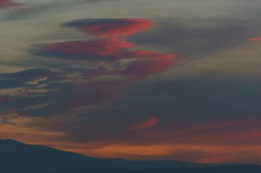 Akşam günbatımında gökyüzünde turuncu kırmızı sıcak renkli bulutlar