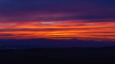 Bardenas Reales Arguedas, Navarra, İspanya yakınlarındaki dağ manzarası üzerinde renkli gökyüzü ile gün batımı