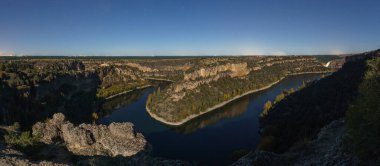 Rio Duraton 'un sonbahar döneminde Sepulveda, Segovia yakınlarındaki Hoces del Duraton doğal parkındaki nehir kıvrımına bakan bir adam panoraması.