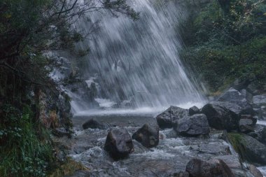 Geres Ulusal Parkı, Vilar da Veiga, Portekiz 'de karanlık bir sonbahar akşamı şelale Cascata de Leonte