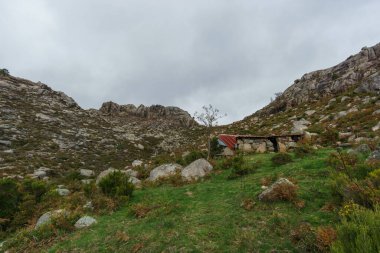 Yeşil bitki örtülü granit kayalardan oluşan dağ manzaralı Cabana da Arrocela, Peneda-Geres Ulusal Parkı, Vilar da Veiga, Portekiz