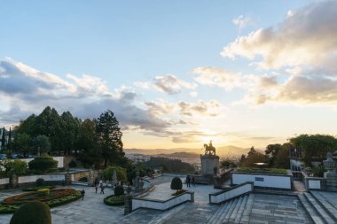 Bom Jesus do Monte Manastırı 'ndan şehrin üzerinde binici heykeliyle akşam güneşinin altın saatinde, Braga, Portekiz