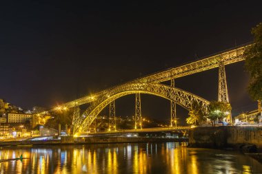 Douro Nehri 'nin su yüzeyinde Vila Nova de Gaia, Porto, Portekiz' den yansıyan ışıklarla Ponte Dom Luis 'de gece görüşü