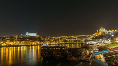 Douro 'da Vila Nova de Gaia, Porto, Portekiz' den botlarla Ponte Dom Luis, Ribeira do Porto ve Katedral 'de gece görüşü