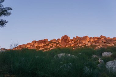 Gün batımında eritilmiş granit kayalar ve mavi akşam gökyüzü, Vale do Rossim, Serra da Estrela, Portekiz