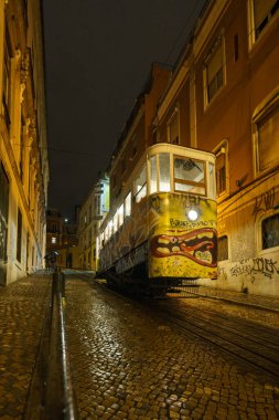 Tarihsel füniküler Elevador da Gloria bir gece boyunca yokuş yukarı çıkmak için bekliyor, Lizbon, Portekiz