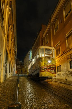 Tarihsel füniküler Elevador da Gloria bir gece boyunca yokuş yukarı çıkmak için bekliyor, Lizbon, Portekiz