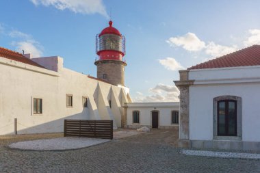 Deniz feneri Cabo de Sao Vicente 'de, mavi bulutlu gökyüzü altın güneş ışığında, Sagres, Algarve, Portekiz