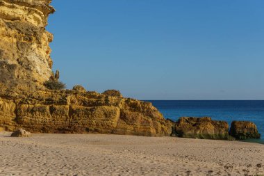 Plaj ve kaya oluşumu Figueira sahilinde altın güneş ışığı altında Atlantik Denizi 'nin önünde, Vila do Bispo, Algarve, Portekiz