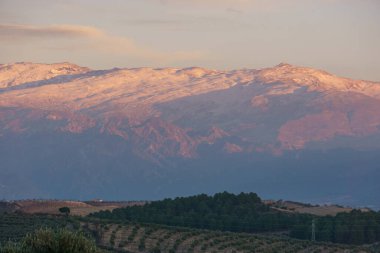 Landscape of Sierra Nevada mountains with snow capped mountain peaks during sunset near Granada, Andalusia, Spain clipart