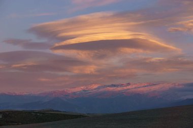 Granada, Endülüs, İspanya yakınlarındaki gün batımında merceksi bulutlu Sierra Nevada dağlarının manzarası