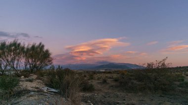Landscape of Sierra Nevada mountains with lenticular clouds during sunset near Granada, Andalusia, Spain clipart