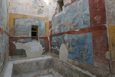 Pompeii, Campania, İtalya 'nın yıkık dökük şehrinde duvarda güzel renkli sanat eserleri olan antik Roma banliyö hamamlarının kalıntılarının içinden bir görüntü.