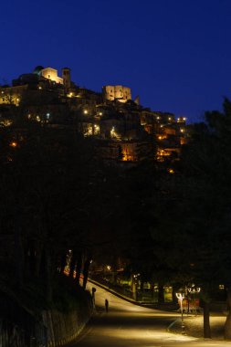 Morano Calabro 'nun alacakaranlıkta sarı sokak ışıklarıyla mavi saat boyunca gece görüşü. Cosenza ili, Calabria, İtalya