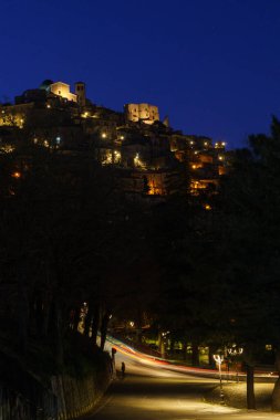 Morano Calabro 'nun alacakaranlıkta sarı sokak ışıklarıyla mavi saat boyunca gece görüşü. Cosenza ili, Calabria, İtalya