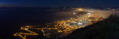 Panoramic view over the city at mediterranean coast from Monte Sant'Elia viewpoint during evening twilight at night, Palmi, Calabria, Italy clipart